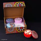 4 scented candle tins in a decorated gift box with one red and one pink lid