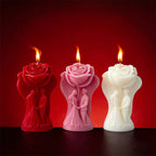 Lit rose-shaped candles in red, pink, and white with visible flames