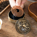 Engraved incense burner with coil incense being placed into the round tray