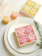 Floral candle set: yellow and pastel rose candles in boxes and around plate