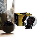 Incense smoke rising beside a foil-lined dish and gold oud box