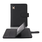 Black passport cover with airplane emblem, hasp flap closure, and visible interior card pockets