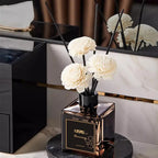 Classic reed diffuser set: black reeds with white flower heads on a square dark bottle