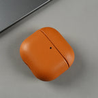 Warm brown eco leather AirPods case, closed with center seam and small dot