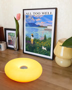 Yellow donut table lamp glowing with circular center opening