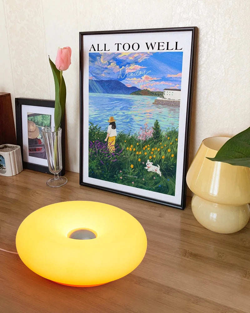 Yellow donut table lamp glowing with circular center opening
