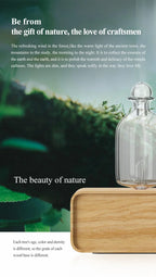 Essential oil diffuser with clear glass bottle and light wood base, close view