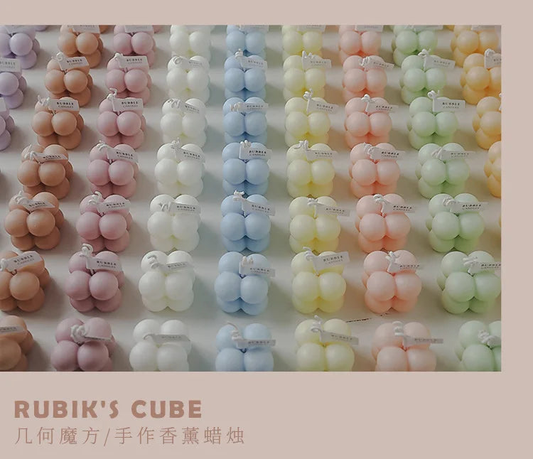 Scattered grid of pastel bubble candles in various colors, each in a clear cube box