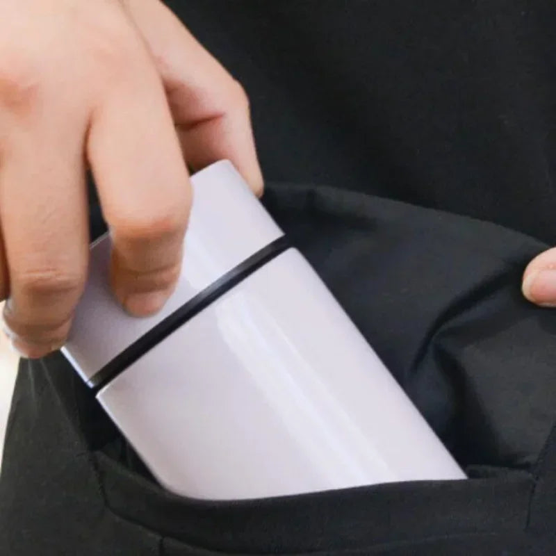 Compact smart thermos with lid open, showing white inner opening and rim.