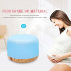 Light blue aroma diffuser humidifier with dark wood base and built-in control panel ring