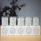 Set of glass jar scented candles with flames; “AMBRE”, “LA VANDE”, “ROSES” labels