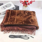 Velvet padded prayer rug in brown with raised arch pattern and long fringe along one edge.