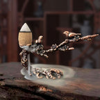 Plum branch incense stand with leaf-shaped metal basin, cone incense and rising smoke