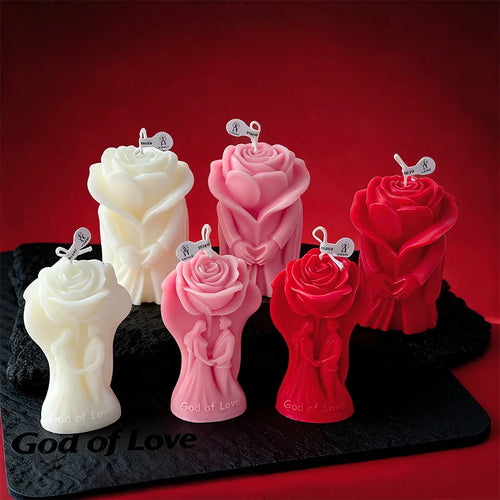 Rose-shaped scented candles in white, pink, and red on a tray