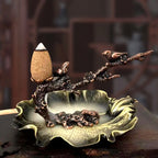 Metal incense stand with plum-branch flowers, leaf bowl, and burning cone holder