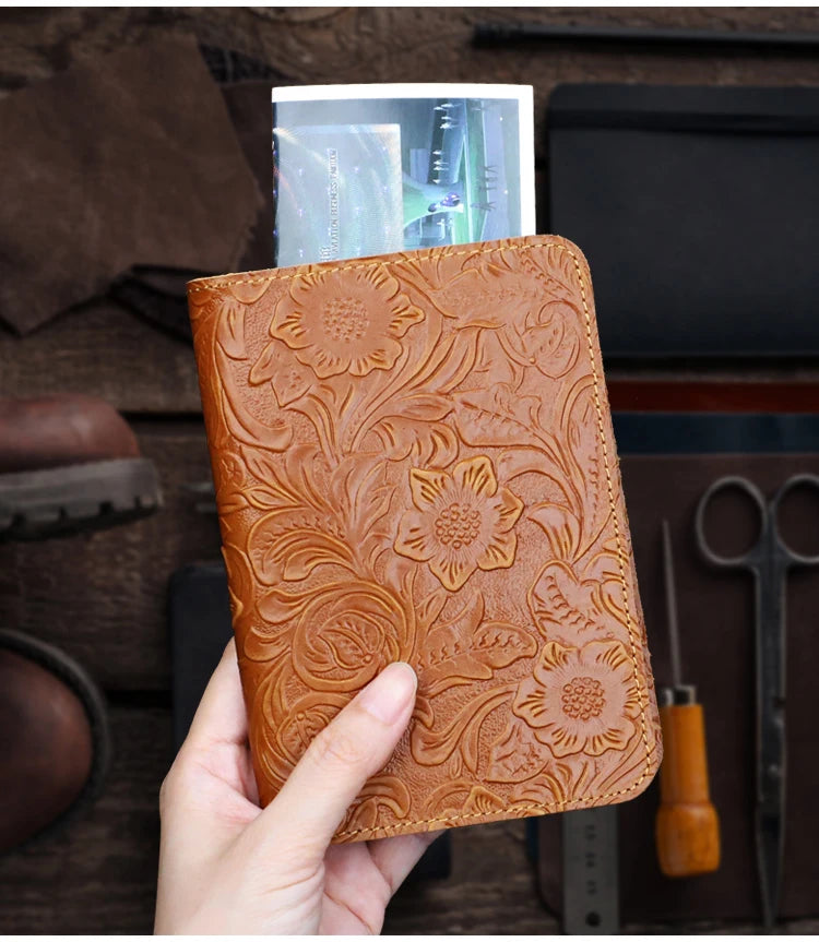 Cognac brown embossed leather travel folio with floral pattern, held upright