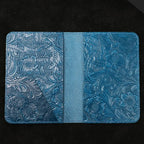 Blue leather travel folio open view with center divider and embossed interior panels