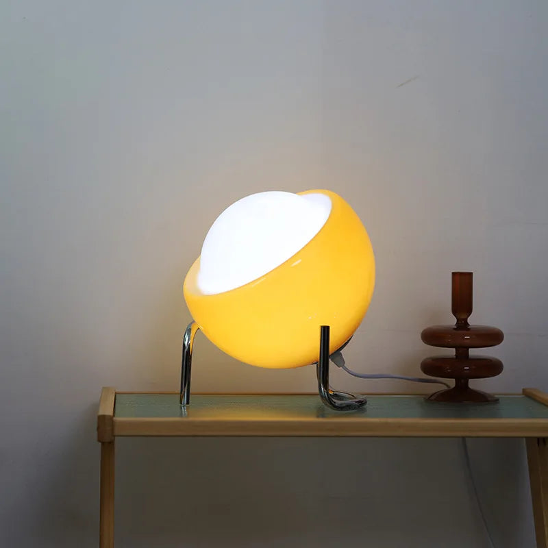 Amber glow glass globe lamp on chrome stand, warm yellow light from oval diffuser
