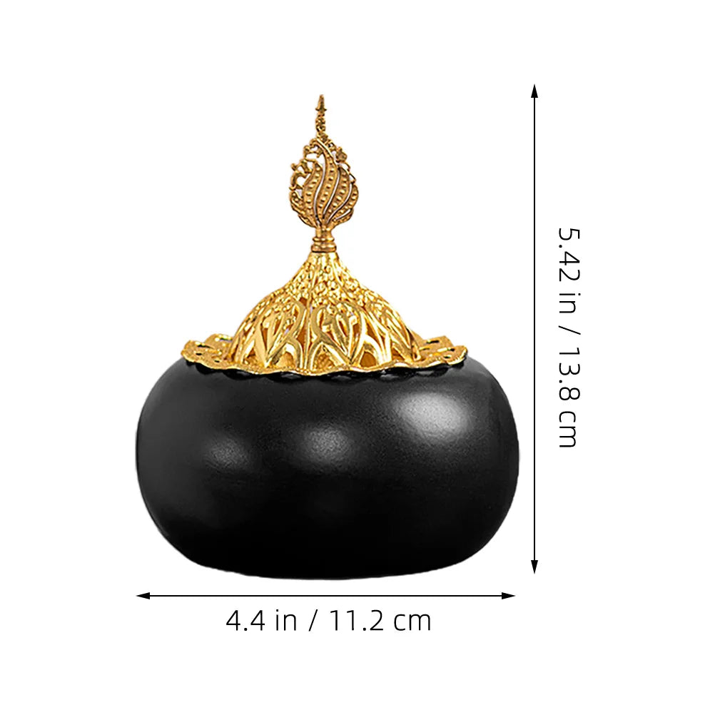 Ceramic oud burner with black dome base and gold openwork ornamental lid, centered view