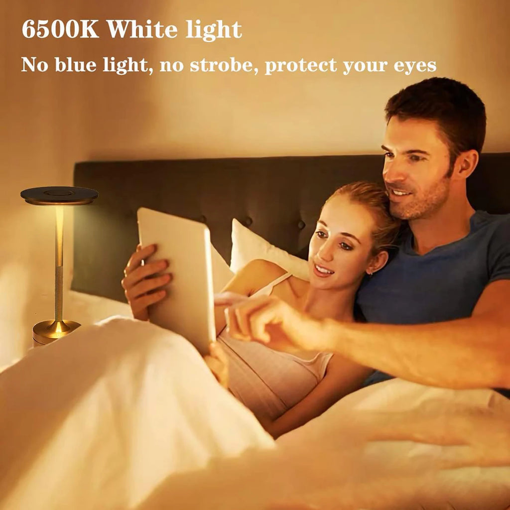 Gold cordless touch reading lamp beside a bed for reading with bright white light