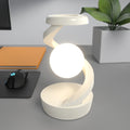 Pearl white floating wireless charging lamp with bright glowing orb and curved light arm