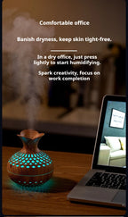 Wood grain mini vase humidifier with teal LED glow emitting mist near a laptop