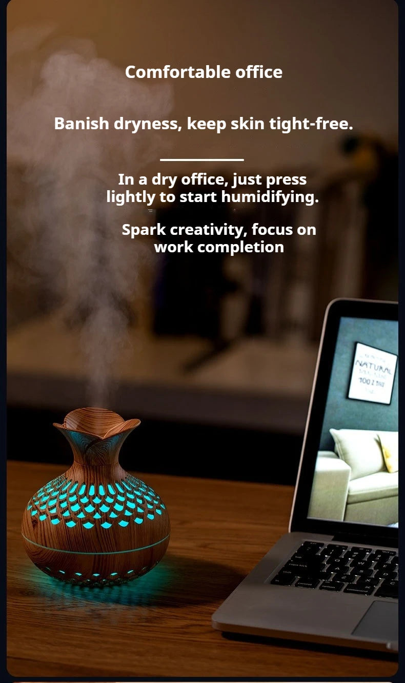 Wood grain mini vase humidifier with teal LED glow emitting mist near a laptop
