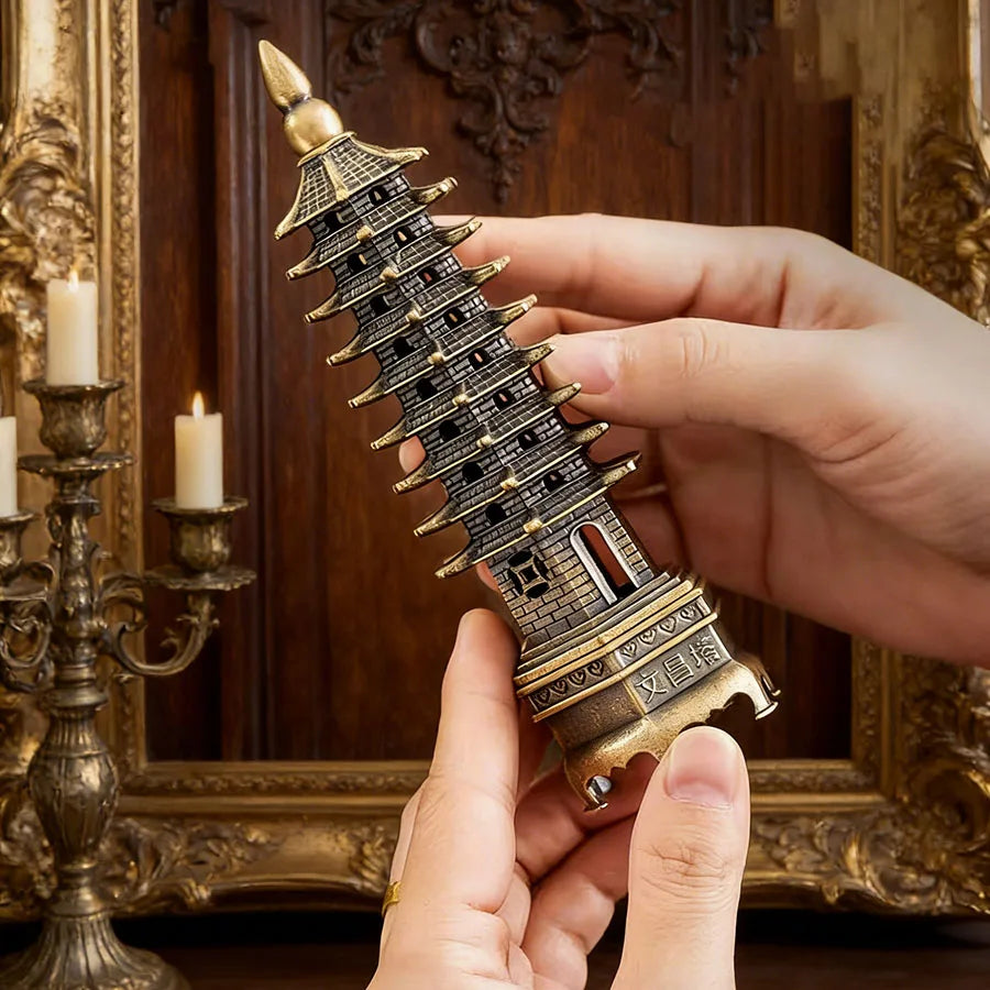 Gold and dark blue tower incense stand with layered roofs, held in hands