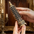 Gold and dark blue tower incense stand with layered roofs, held in hands