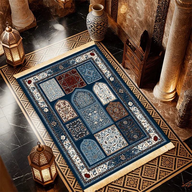 Islamic-style prayer mat with blue center panels, ornate border, and off-white fringe