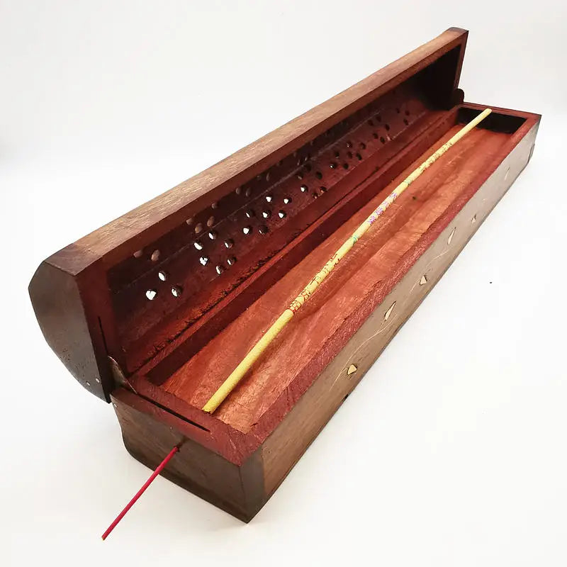 Carved rosewood incense holder with open lid, brass incense stick rests inside