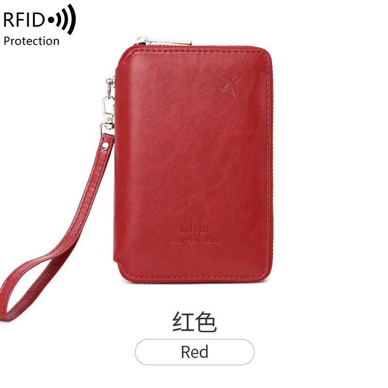 Cardinal red RFID passport sleeve with wrist strap and top zipper; minimalist embossed emblem