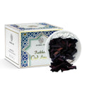 Dark oud incense pieces in a foil-lined dish with a white-and-blue box