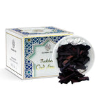 Dark oud incense pieces in a foil-lined dish with a white-and-blue box