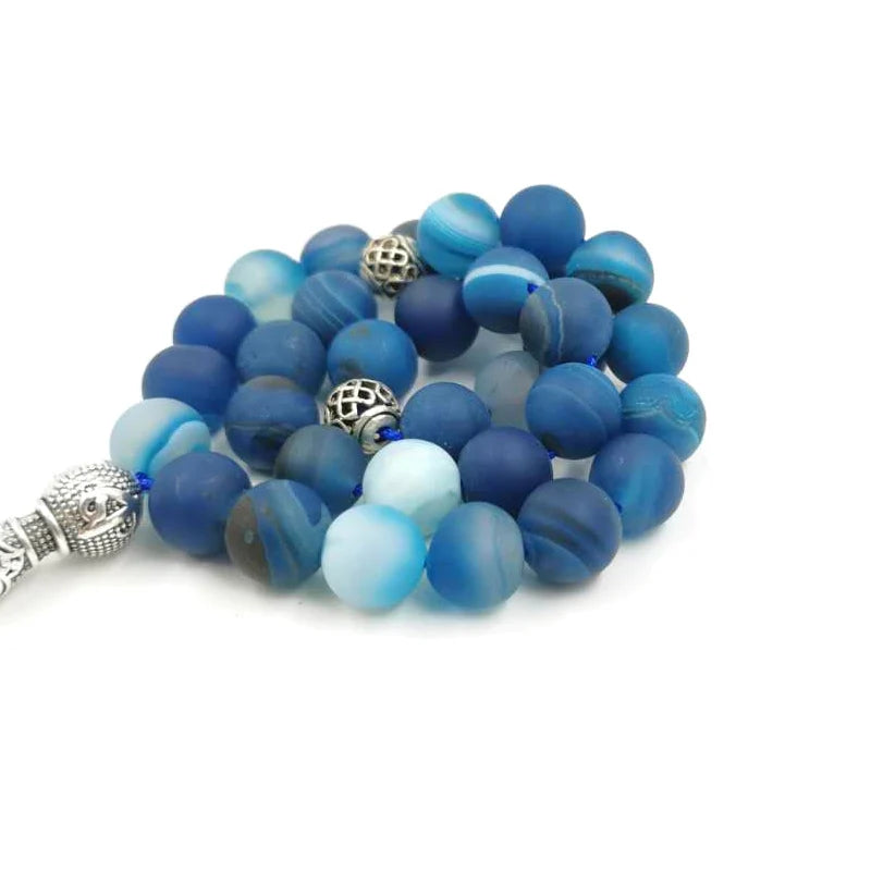 Blue agate prayer beads with silver-tone spacer beads, close-up of round matte stones