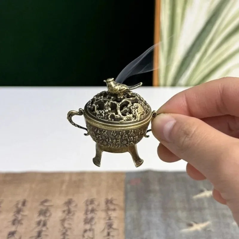 Copper lotus incense burner with bird finial and decorative lid, opened to show ash bowl