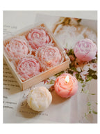 Pastel rose wax candles in a clear gift box: light pink and lavender candles, some lit