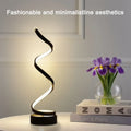 Spiral dimmable LED bedside lamp, black wavy light head on round black base