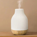 White ribbed ceramic aroma diffuser with tan wood base and two side button details
