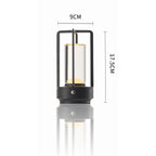 Lantern-style table reading lamp with rectangular frame, dark finish and warm glow