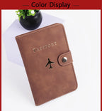 Cognac brown passport folio with airplane logo and side snap closure, faux leather look