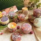Multiple floral aromatherapy candles in patterned tins, one lit