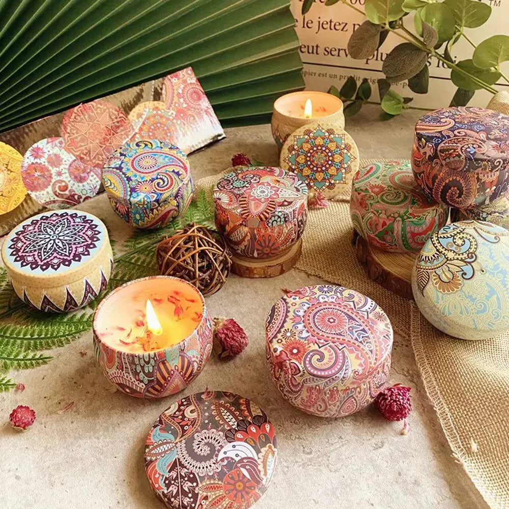 Multiple floral aromatherapy candles in patterned tins, one lit