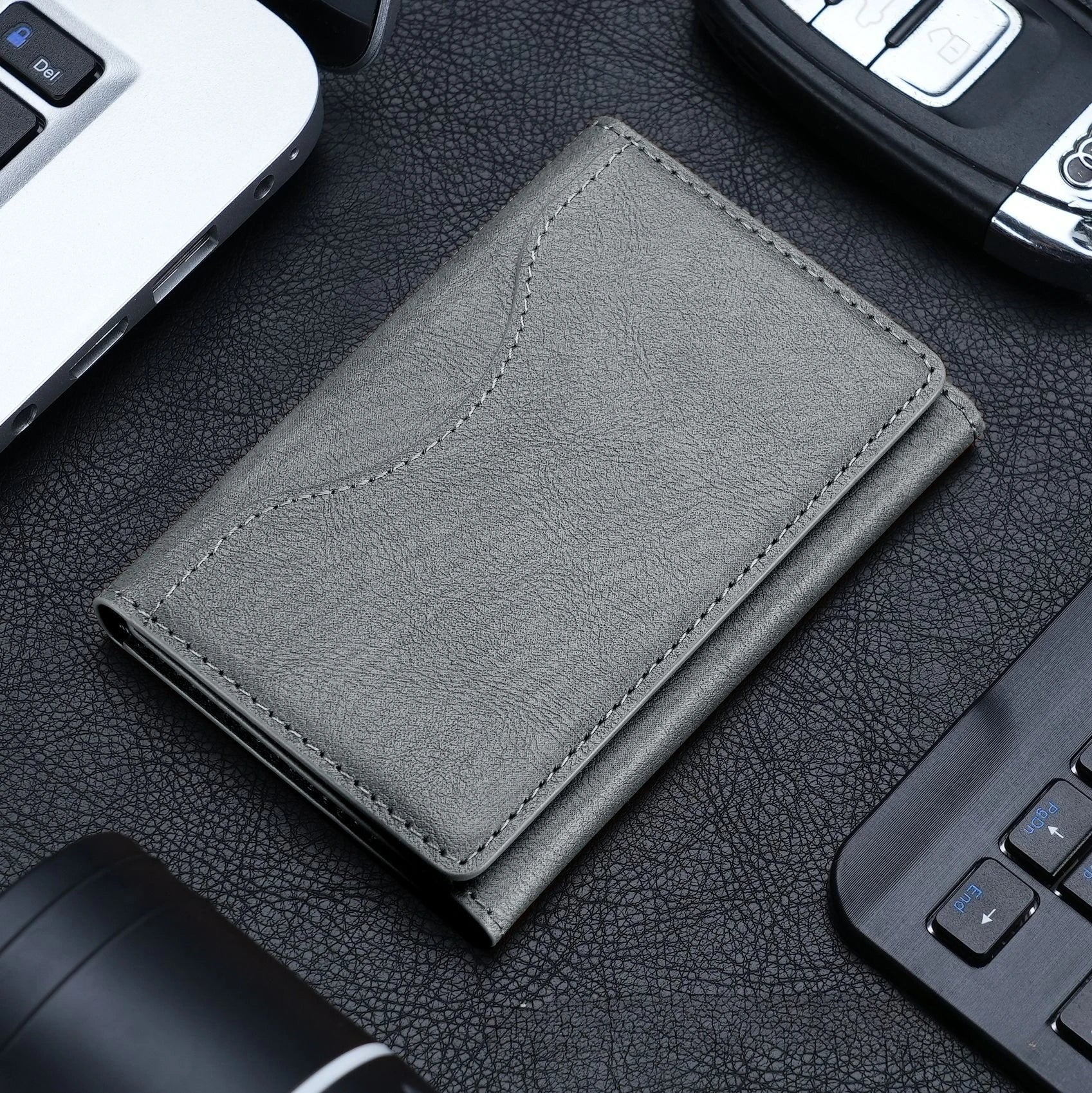 Magnetic pouch wallet in gray leather, stitched edges, front flap detail