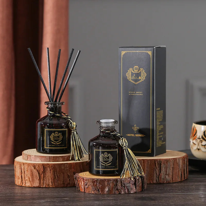 Signature reed diffuser set with dark glass bottle, black reeds, tassel cap, and cardboard box