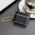 Obsidian (dark) wrist strap AirPods case with gold chain and gold trim.