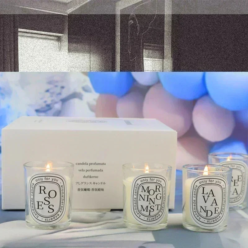 Romantic glass jar scented candles with flames and white wax; gift box behind