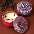 Zwei Vintage Duftkerzen aus dem 4er-Set: rote und farbige Mandala-Deckel, Flamme sichtbar