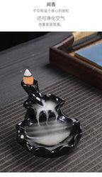 Tower backflow incense burner with white cone tip and swirling smoke pool in black tray