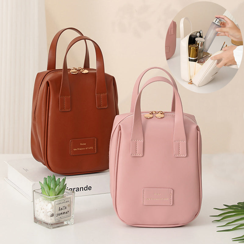 Two-shell travel vanity bags, brown and pink, with top handles and gold clasp detail.